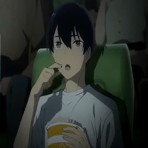 Tsuneo comiendo palomitas de maíz mientras ve una película en el cine