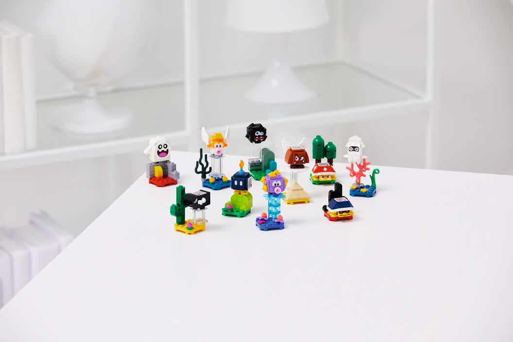 Pequeños modelos LEGO de personajes enemigos coleccionables sentados en una mesa blanca